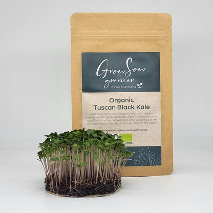 organic black kale microgreen and sprouting seeds growing in front of a compostable pouch