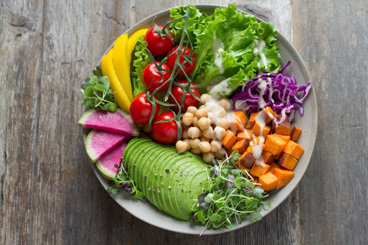A colourful salad bowl of fresh vegetables topped with microgreens