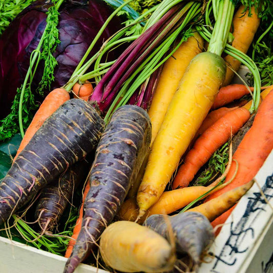 a vegetable box with rainbow coloured carrots in the uk